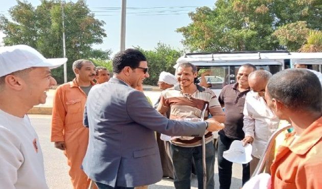 نائب محافظ سوهاج يوزع مواد غذائية وزجاجات مياه وأغطية رأس على عمال النظافة